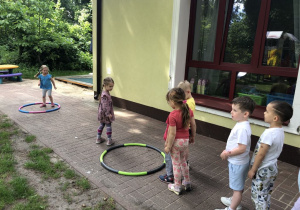 Dzieci skaczą przez koła