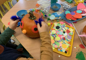 Dziecko ozdabia dynię