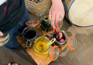 Dzieci zanurzają jajka w barwnikach