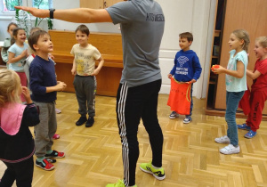 Trener pokazuje ćwiczenie dzieciom